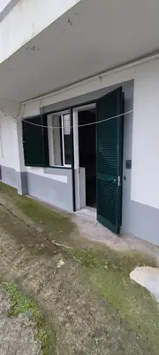 a green door on the side of a building at Ape T0 in São Vicente