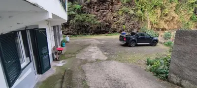a black truck parked in a driveway next to a house at Ape T0 in São Vicente