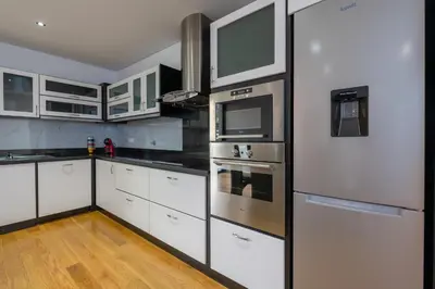 a kitchen with white cabinets and stainless steel appliances at Oceanfront Villa with Private Pool Breathtaking Sunsets in Madeira in Tábua