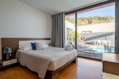 a bedroom with a bed and a large window at Oceanfront Villa with Private Pool Breathtaking Sunsets in Madeira in Tábua