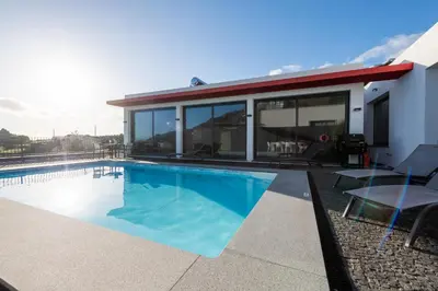 a house with a swimming pool and a building at Oceanfront Villa with Private Pool Breathtaking Sunsets in Madeira in Tábua