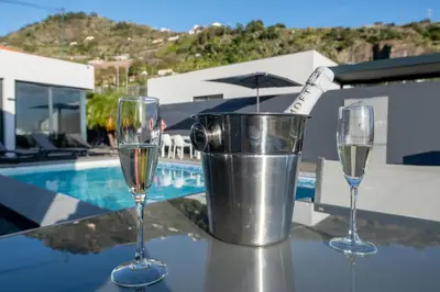 two glasses of wine on a table near a pool at Oceanfront Villa with Private Pool Breathtaking Sunsets in Madeira in Tábua