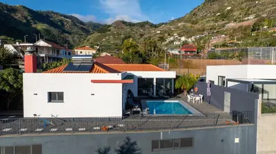 a house with a swimming pool and a mountain at Oceanfront Villa with Private Pool Breathtaking Sunsets in Madeira in Tábua