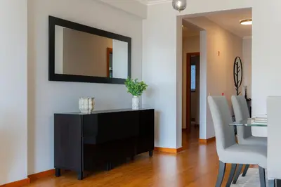 a dining room with a mirror on the wall at Anchored in Carmo by Homie in Câmara de Lobos