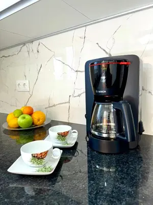 a coffee maker and two cups on a counter at O Cantinho do Zé - Signature Funchal in Funchal