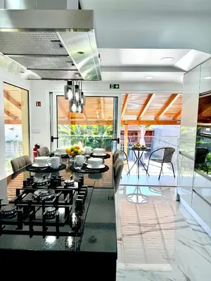 a living room with a kitchen and a dining room at O Cantinho do Zé - Signature Funchal in Funchal