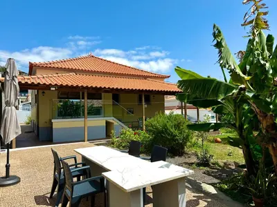 a table and chairs in front of a house at O Cantinho do Zé - Signature Funchal in Funchal