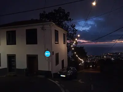 a building with a blue sign on the side of it at night at Casa de férias Funchal in Nossa Senhora do Monte