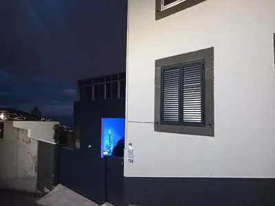 a building with a window and a blue christmas tree at Casa de férias Funchal in Nossa Senhora do Monte
