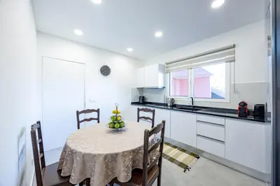 a kitchen with a table and chairs in a room at Vivenda Paz Lobo by YOUR KEY MADEIRA in Gaula