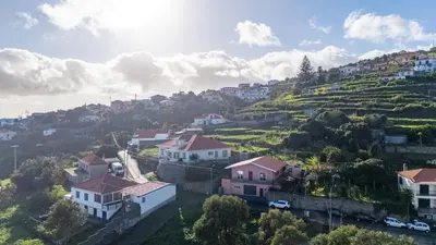 a village on a hill with houses and cars at Vivenda Paz Lobo by YOUR KEY MADEIRA in Gaula