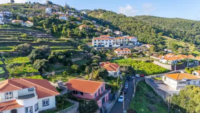 a village on a hill with houses and cars at Vivenda Paz Lobo by YOUR KEY MADEIRA in Gaula