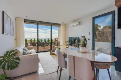 a living room with a table and a couch at BHF Residences Luxe Sunset in Arco da Calheta