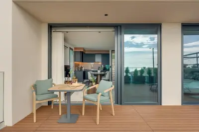 a dining room with a table and chairs on a balcony at BHF Residences Luxe Sunset in Arco da Calheta