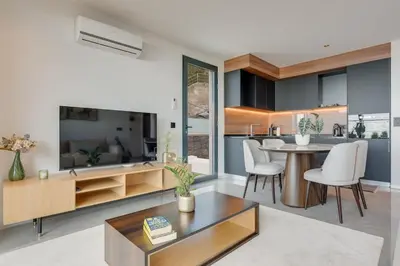 a kitchen and living room with a table and chairs at BHF Residences Luxe Sunset in Arco da Calheta