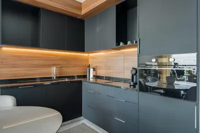 a kitchen with black cabinets and a dining room at BHF Residences Luxe Sunset in Arco da Calheta