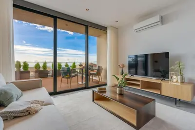 a living room with a couch and a tv and a table at BHF Residences Luxe Sunset in Arco da Calheta
