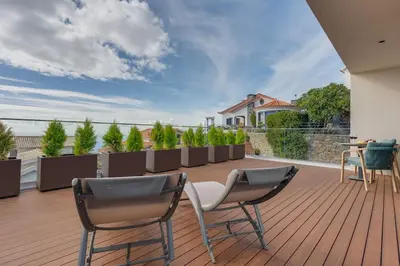 a patio with two chairs and a table on a deck at BHF Residences Luxe Sunset in Arco da Calheta