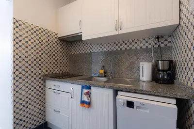 a kitchen with white cabinets and a sink at Apartamento Navio Azul in Funchal