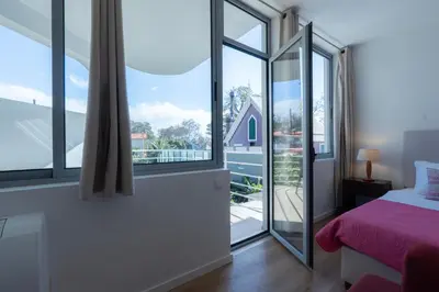 a bedroom with a bed and a large window at Apartamento Navio Azul in Funchal