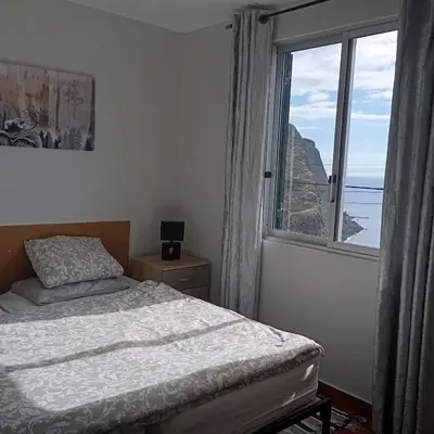 a bedroom with a bed and a large window at Yellow owl in Campanário