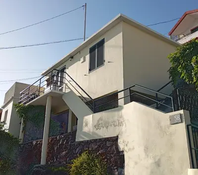 a house with a staircase in front of it at Yellow owl in Campanário