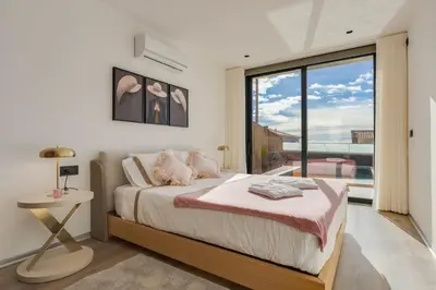 a bedroom with a bed and a large window at BHF Residences Luxe Family in Arco da Calheta