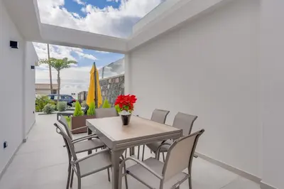 a dining room with a table and chairs at BHF Residences Luxe Family in Arco da Calheta