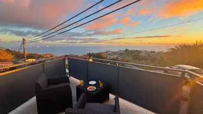 a balcony with a table and chairs at sunset at Sophia House By Sam Houses in Canhas