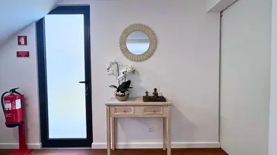 a room with a table and a mirror on the wall at Sophia House By Sam Houses in Canhas