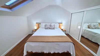 a bedroom with a large bed and two mirrors at Sophia House By Sam Houses in Canhas