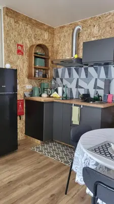 a kitchen with a black refrigerator and a table at CasAmor - Romantic Ocean View Studio in Santa Cruz