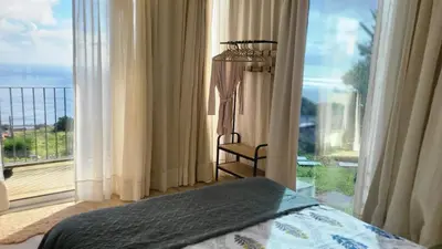 a bedroom with a bed and a large window at CasAmor - Romantic Ocean View Studio in Santa Cruz