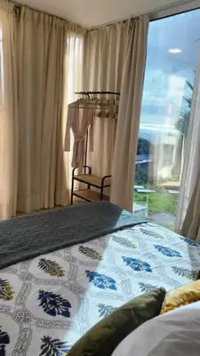 a bedroom with a bed and a large window at CasAmor - Romantic Ocean View Studio in Santa Cruz