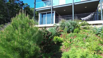 a house with a hammock in a garden at CasAmor - Romantic Ocean View Studio in Santa Cruz