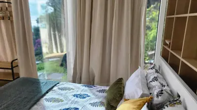 a bedroom with a bed and a large window at Personal blue house Madeira in Santa Cruz