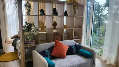 a living room with a couch and shelves with plants at Personal blue house Madeira in Santa Cruz