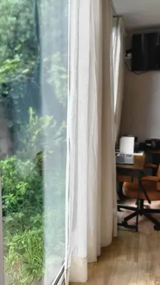 a window with white curtains in a room at Personal blue house Madeira in Santa Cruz