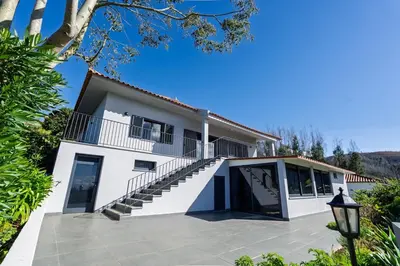 a white house with stairs and a balcony at Passaras - countryside retreat in west of island in Ponta do Pargo