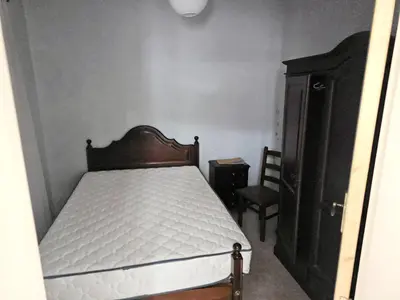 a small bedroom with a bed and a dresser at Funchal Pink Hostel in Funchal