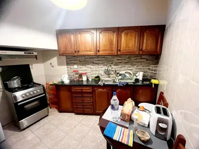 a kitchen with wooden cabinets and a counter top at Funchal Pink Hostel in Funchal
