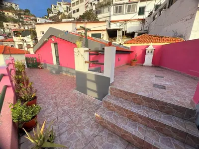 a courtyard of a house with pink walls at Funchal Pink Hostel in Funchal