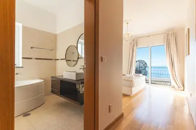 a bathroom with a tub and a sink and a mirror at Villa Valentina by Atlantic Holiday in Ponta do Sol