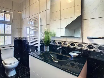 a bathroom with a sink and a toilet and a mirror at Villa Baradaye by Atlantic Holiday in Estreito da Calheta