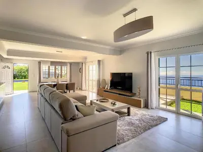 a large living room with a couch and a tv at Villa Baradaye by Atlantic Holiday in Estreito da Calheta