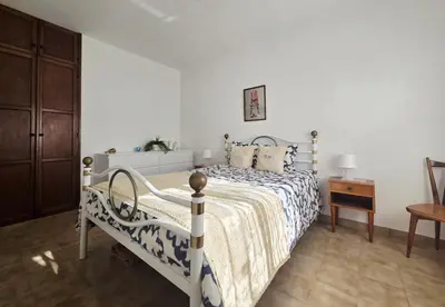 a white bedroom with a bed and a table at Vivenda Chagas in Luz