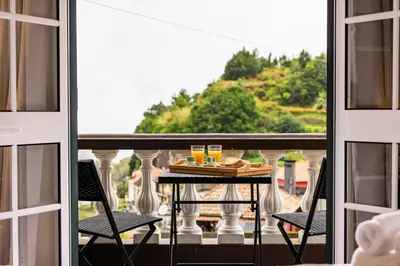 a table with a plate of food on a balcony at View to the Valley, By OP in Senhora do Rosário