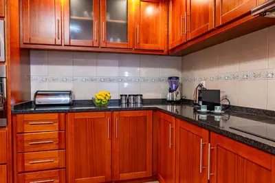 a kitchen with wooden cabinets and a bowl of fruit on the counter at View to the Valley, By OP in Senhora do Rosário
