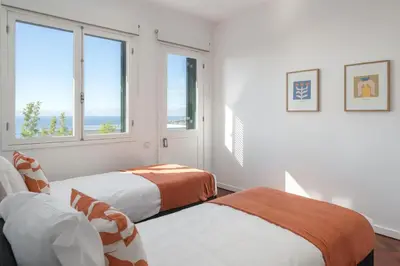 two beds in a white room with two windows at Casa da Anoneira House with Pool and Sea View in Funchal