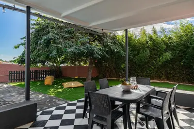 a patio with a table and chairs on a checkered floor at Casa da Anoneira House with Pool and Sea View in Funchal